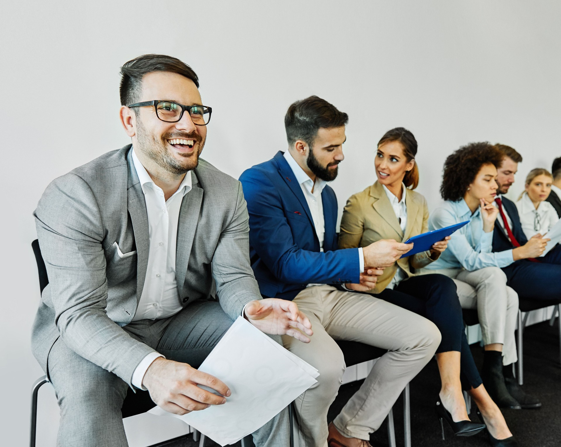 man business chair sitting waiting businessman candidate recruitment office businesswoman woman businessperson job young interview line employee career row hall colleague