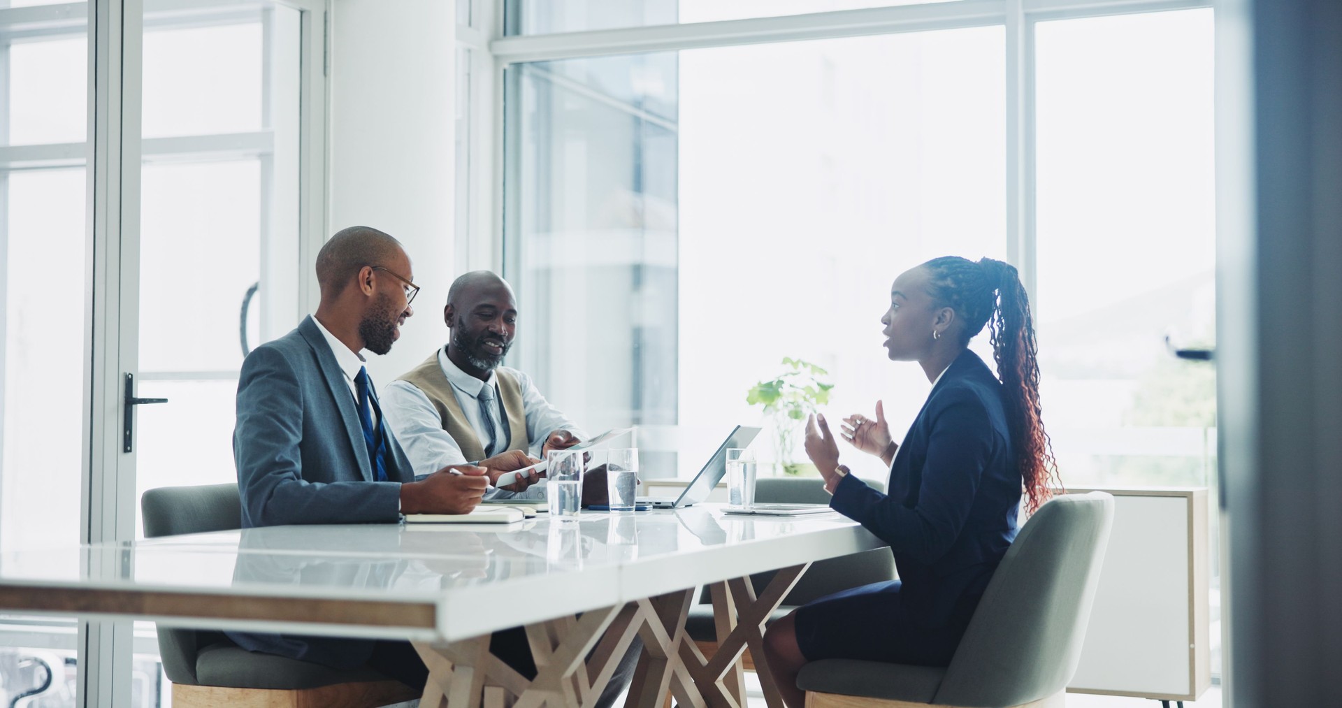Boss, employee and conversation in office on interview for job or career opportunity and growth. Black people, candidate and woman in boardroom with paperwork on discussion with hiring team or hr